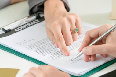 İşkadını işaretleri sözleşmesi sözleşme ile ofiste başka bir iş kadını. Kadının el ateş yakın. İş ortaklığı ve avukat yasal faaliyetleri kavramı.