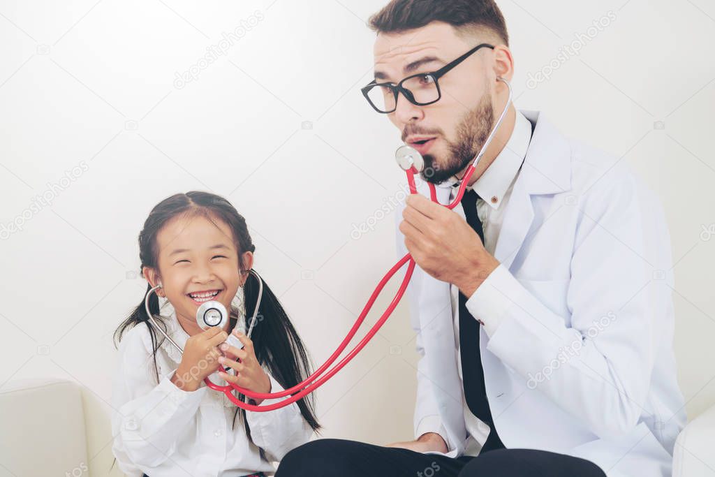 Little kid visit doctor in hospital office. The kid is happy and not afraid of the doctor. Medical and children healthcare concept.