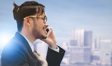 Gerçeküstü iletişim kavramı - genç işadamı istimal hareket eden telefon ile modern şehir binaları arka plan görüntüsü. Gelecek yenilik teknoloji ve Internet şey (çok ).