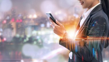 Cep telefonu ile modern şehir binaları arka plan kullanarak genç iş kadını. Gelecekteki telekomünikasyon teknolojisi ve internet şeyler (çok) kavramının.