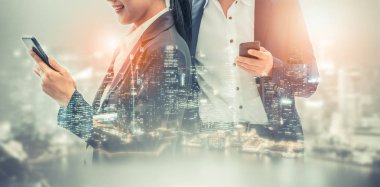 Cep telefonu ile modern şehir binaları arka plan kullanarak genç iş adamları. Gelecekteki telekomünikasyon teknolojisi ve internet şeyler (çok) kavramının.