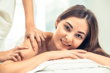 Lüks Spa arka planda profesyonel masaj terapisti ile omuz masaj yaptırdığım rahat kadın. Sağlık, şifa ve dinlenme kavramı.