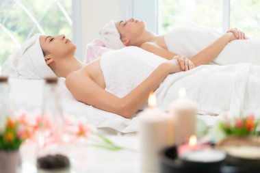 Spa yatağında uzanan rahat genç bir kadın lüks bir spa merkezinde yüz bakımı ve masaj için hazırlandı. Sağlık, stres atma ve gençleştirme kavramı.