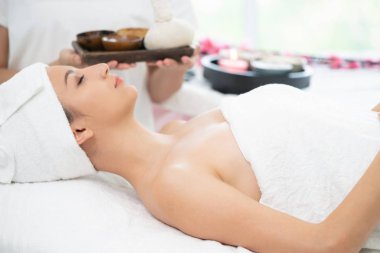 Rahat kadın kaplıca tedavisi planda tutan terapist ile spa masaj için hazırlanan spa yatakta yalan. Lüks sağlık, stres rahatlama ve gençleşme kavramı.