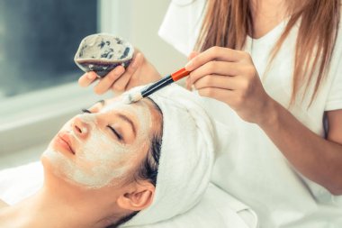 Güzeller güzeli kadın, sağlık merkezindeki profesyonel dermatologdan yüz temizleme tedavisi görüyor. Yaşlanma önleyici, yüz bakımı ve lüks yaşam tarzı konsepti.