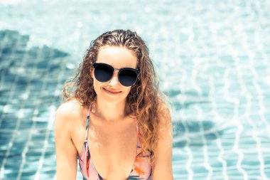 Mutlu genç kadın lüks resort yüzme havuzunda, iyi vakit geçiriyor mayo giyiyor. Yaz seyahat tatil kavramı.