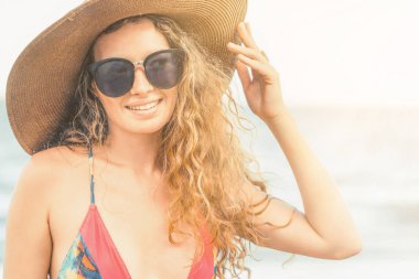 Tatil seyahat etmek tatil için yaz aylarında tropikal plaj keyfi yerinde mayo giyen mutlu genç kadın.