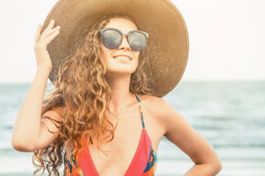 Tatil seyahat etmek tatil için yaz aylarında tropikal plaj keyfi yerinde mayo giyen mutlu genç kadın.