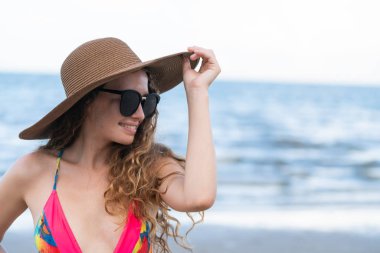 Tatil seyahat etmek tatil için yaz aylarında tropikal plaj keyfi yerinde mayo giyen mutlu genç kadın.