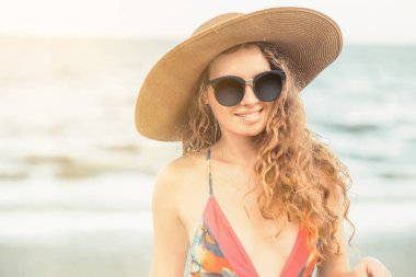 Tatil seyahat etmek tatil için yaz aylarında tropikal plaj keyfi yerinde mayo giyen mutlu genç kadın.