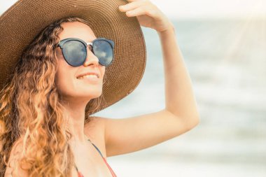 Tatil seyahat etmek tatil için yaz aylarında tropikal plaj keyfi yerinde mayo giyen mutlu genç kadın.