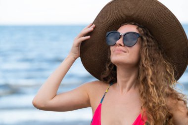 Tatil seyahat etmek tatil için yaz aylarında tropikal plaj keyfi yerinde mayo giyen mutlu genç kadın.