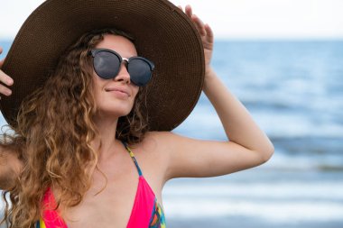 Tatil seyahat etmek tatil için yaz aylarında tropikal plaj keyfi yerinde mayo giyen mutlu genç kadın.