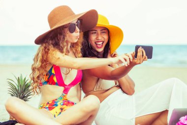 Mutlu kadın selfie fotoğraf birlikte cep telefonundan tropikal kum plaj yaz tatile içinde bikinis. Seyahat yaşam tarzı.