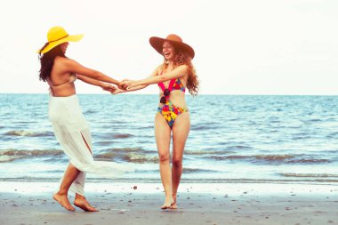 Bikinili mutlu kadın birlikte yaz tatil tropikal Kum Plajı üzerinde dans. Seyahat yaşam tarzı.