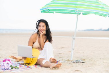 Artı boyutu yaz aylarında tropikal Kum Plajı üzerinde oturan bir genç bayan. Tatil seyahat etmek tatil.