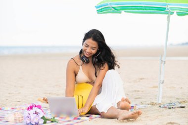 Artı boyutu yaz aylarında tropikal Kum Plajı üzerinde oturan bir genç bayan. Tatil seyahat etmek tatil.