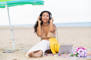 Artı boyutu yaz aylarında tropikal Kum Plajı üzerinde oturan bir genç bayan. Tatil seyahat etmek tatil.