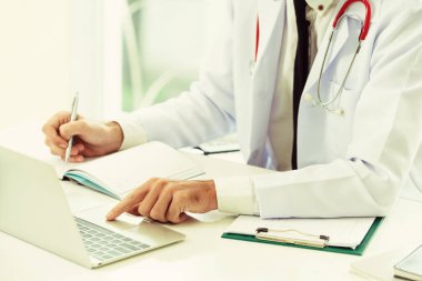 Doktor hastanede Ofis masaları, dizüstü bilgisayar üzerinde çalışıyor. Tıbbi ve sağlık kavramı.