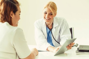 Kadın doktor konuşuyor ve Bayan hasta hastane ofisinde inceleyerek. Sağlık ve tıbbi hizmet.