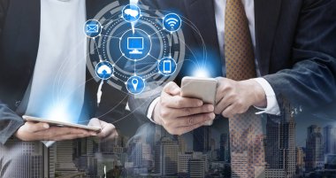 Cep telefonu ile modern şehir binaları arka plan kullanarak genç iş adamları. Gelecekteki telekomünikasyon teknolojisi ve internet şeyler (çok) kavramının.