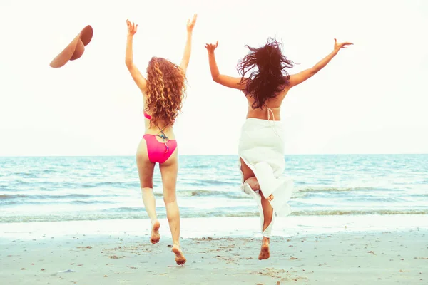 在夏季假期 在热带沙滩上 穿着比基尼的快乐女人一起跳在空中 旅游生活方式 — 图库照片