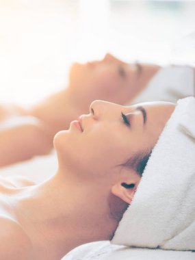 Spa yatağında uzanan rahat genç bir kadın lüks bir spa merkezinde yüz bakımı ve masaj için hazırlandı. Sağlık, stres atma ve gençleştirme kavramı.