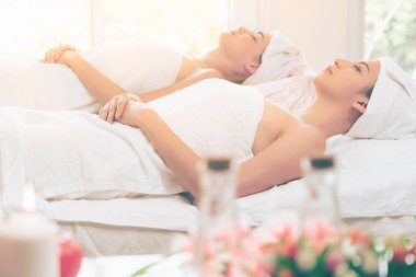 Spa yatağında uzanan rahat genç bir kadın lüks bir spa merkezinde yüz bakımı ve masaj için hazırlandı. Sağlık, stres atma ve gençleştirme kavramı.