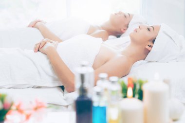 Spa yatağında uzanan rahat genç bir kadın lüks bir spa merkezinde yüz bakımı ve masaj için hazırlandı. Sağlık, stres atma ve gençleştirme kavramı.