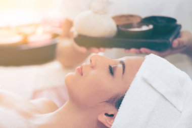 Rahat kadın kaplıca tedavisi planda tutan terapist ile spa masaj için hazırlanan spa yatakta yalan. Lüks sağlık, stres rahatlama ve gençleşme kavramı.