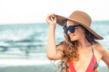 Tatil seyahat etmek tatil için yaz aylarında tropikal plaj keyfi yerinde mayo giyen mutlu genç kadın.