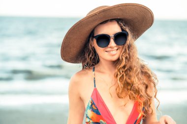 Tatil seyahat etmek tatil için yaz aylarında tropikal plaj keyfi yerinde mayo giyen mutlu genç kadın.