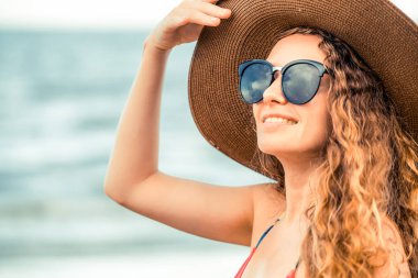 Tatil seyahat etmek tatil için yaz aylarında tropikal plaj keyfi yerinde mayo giyen mutlu genç kadın.