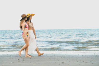 Bikinili mutlu kadın birlikte yaz tatil tropikal kum plaj güneşlenme gitmek. Seyahat yaşam tarzı.