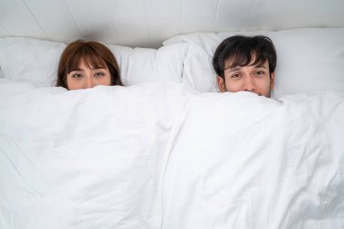 Mutlu genç çift rahatlatıcı sabah uyandıktan sonra eve yatak odasında.