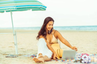 Artı boyutu yaz aylarında tropikal Kum Plajı üzerinde oturan bir genç bayan. Tatil seyahat etmek tatil.