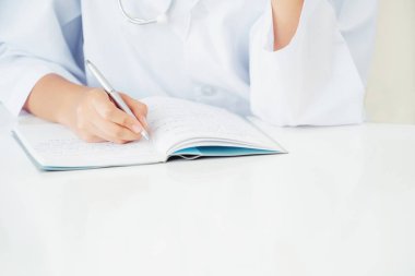 Doktor hastanede ofiste dizüstü rapor yazma görüntüsünü kapatın. Sağlık profesyonel.