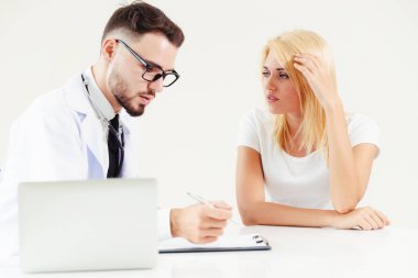 Hastanın sağlık kaydının tablosundaki tarih yazarken hastane ofiste bayan hasta için erkek doktor konuşuyor. Sağlık ve tıbbi hizmet.