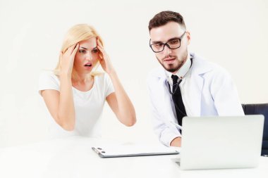 Erkek doktor hastane ofiste bayan hasta masada dizüstü bilgisayarda hastalar sağlık verilere bakarken konuştuğu. Sağlık ve tıbbi hizmet.