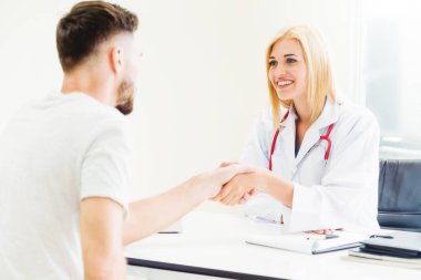 Kadın doktor hastane office odasında erkek hasta ile karşılıklı yapıyor. Sağlık ve Medikal hizmet meslekleri.