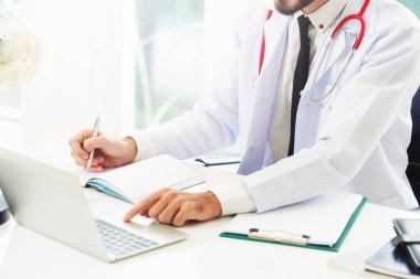 Doktor hastanede Ofis masaları, dizüstü bilgisayar üzerinde çalışıyor. Tıbbi ve sağlık kavramı.
