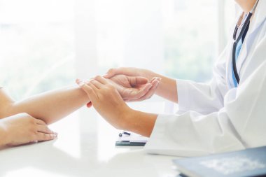 Kadın doktor hastane ofiste bayan hasta için eller tarafından hasta darbe incelenirken konuşuyor. Sağlık ve tıbbi hizmet.