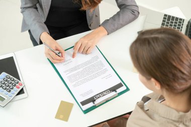 İşkadını işaretleri sözleşmesi sözleşme ile ofiste başka bir iş kadını. Kadının el ateş yakın. İş ortaklığı ve avukat yasal faaliyetleri kavramı.