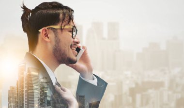 Gerçeküstü iletişim kavramı - genç işadamı istimal hareket eden telefon ile modern şehir binaları arka plan görüntüsü. Gelecek yenilik teknoloji ve Internet şey (çok ).