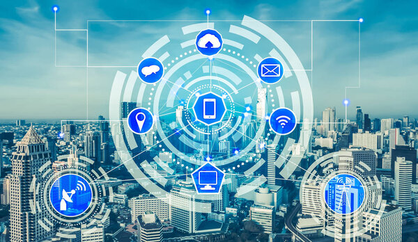 Smart city wireless communication network with graphic showing concept of internet of things (IOT) and information communication technology (ICT) against modern city buildings in the background.