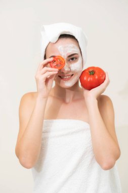 Bir yüz maskesi tedavi ile domates krem ayıklayabilirsiniz doğa tedavisinin yararı gösterilen sahip güzel bir kadın. Anti-aging kozmetik, yüz cilt bakımı ve lüks yaşam tarzı kavramı.