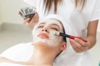 Güzeller güzeli kadın, sağlık merkezindeki profesyonel dermatologdan yüz temizleme tedavisi görüyor. Yaşlanma önleyici, yüz bakımı ve lüks yaşam tarzı konsepti.