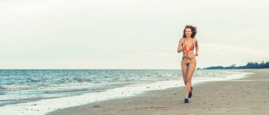 Çekici kadın runner yaz aylarında tropikal Kum Plajı üzerinde çalışır. Sağlıklı yaşam tarzı ve koşma spor kavramı.