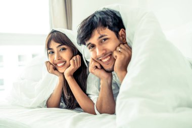 Mutlu genç çift rahatlatıcı sabah uyandıktan sonra eve yatak odasında.