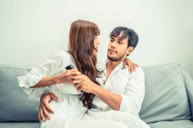 Genç bir çift kavga TV uzaktan sabahları evde oturma odasında kanepede.